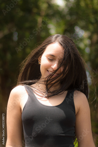 portrait of young latin woman with long hair smiling and walking in nature