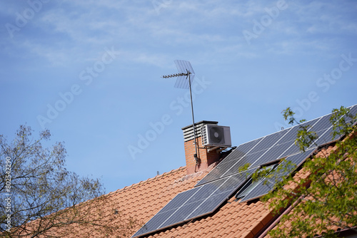 Placas solares sobre tejado de una vivienda y cielo azul. Energía photo