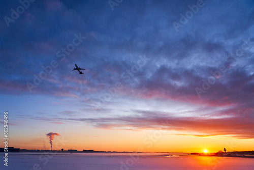 The plane is landing at dawn in heavy fog in winter. The silhouette of an airplane