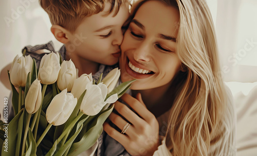 A mother hugging their son on mother's day with a bunch of flowers photo