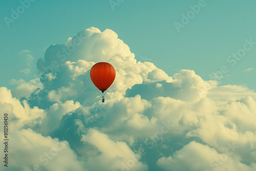 A single balloon floating against a backdrop of fluffy white clouds.