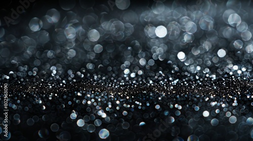 Shimmering silver sparkles on a dark background create a mesmerizing texture.