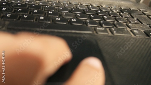 POV: person using a laptop touchpad. Man using a laptop keyboard. Person using a notebook. A QWERTY keyboard. A computer keyboard. A laptop trackpad photo