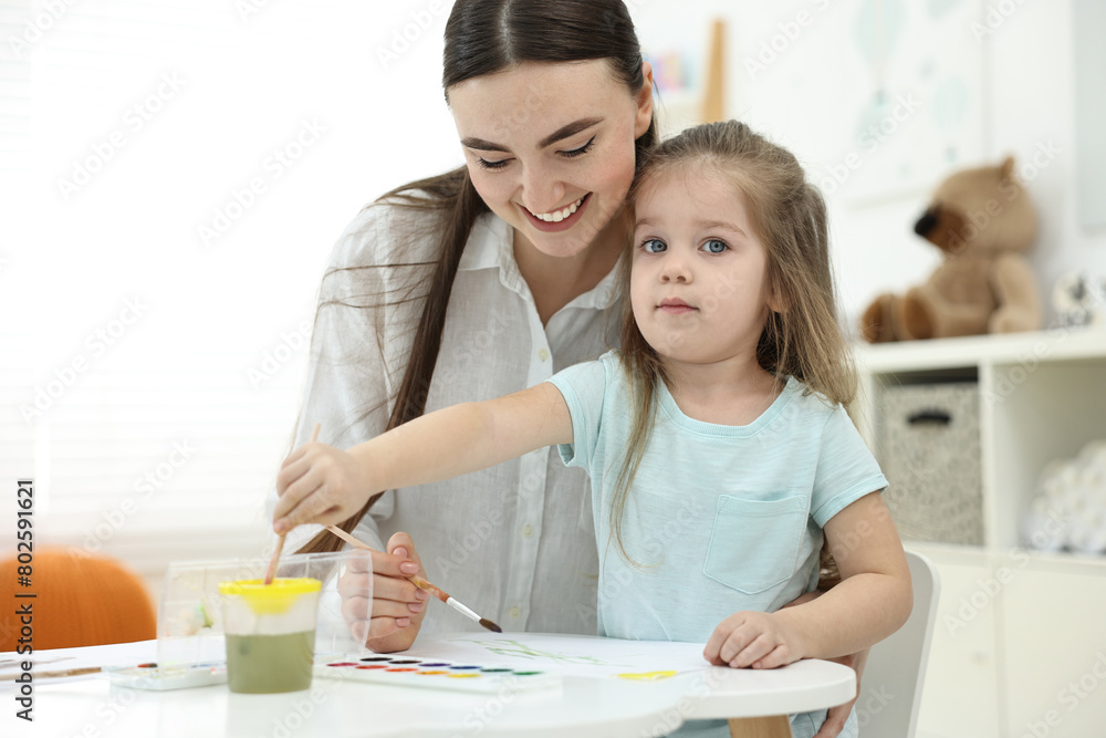 Mother and her little daughter painting with watercolor at home Mother and her little daughter painting with watercolor at home
