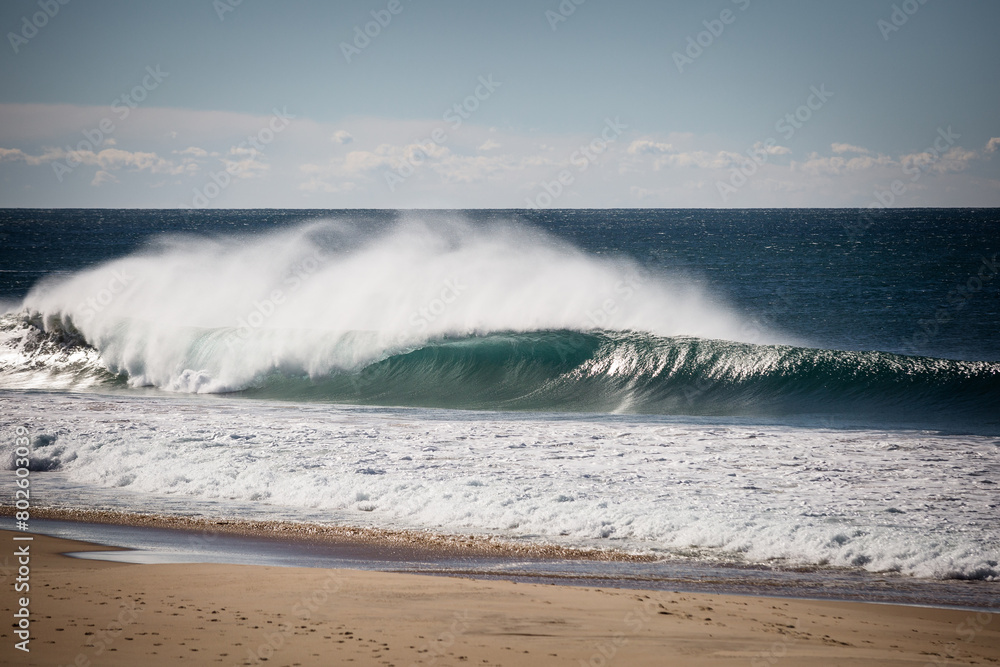 Large tubular wave breaking along the shoreline 