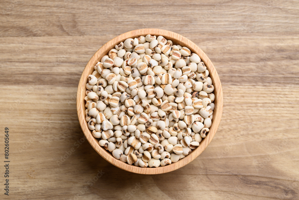 Dried Job's tears or adlay millet in wooden bowl on wooden background, Table top view Dried Job's tears or adlay millet in wooden bowl on wooden background, Table top view
