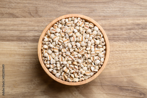 Dried Job's tears or adlay millet in wooden bowl on wooden background, Table top view