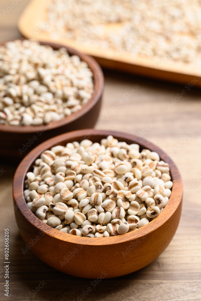 Dried Job's tears or adlay millet in wooden bowl on wooden background