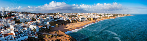 Aerial view of seaside Albufeira with wide beach and white architecture, Algarve, Portugal. Wide sandy beach in city of Albufeira, Algarve, Portugal. Aerial view of Albufeira town, Algarve, Portugal.