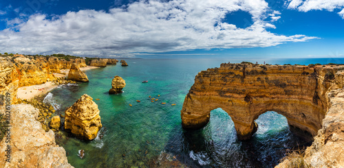 Natural caves at Marinha beach, Algarve Portugal. Rock cliff arches on Marinha beach and turquoise sea water on coast of Portugal in Algarve region.