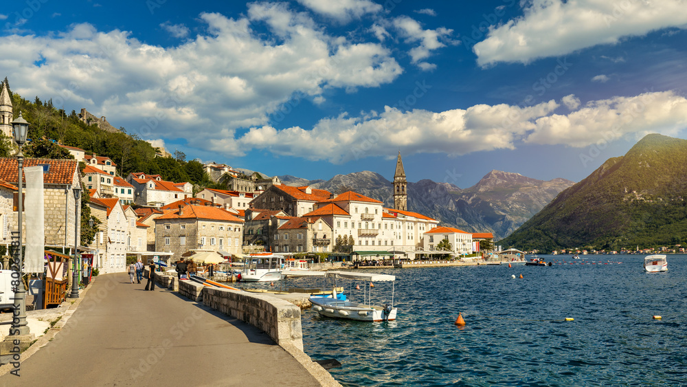 Obraz premium View of the historic town of Perast at famous Bay of Kotor on a beautiful sunny day with blue sky and clouds in summer, Montenegro. Historic city of Perast at Bay of Kotor in summer, Montenegro.