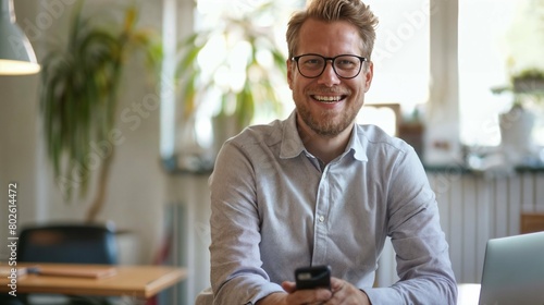 Happy businessman with a phone and laptop in a modern office space.