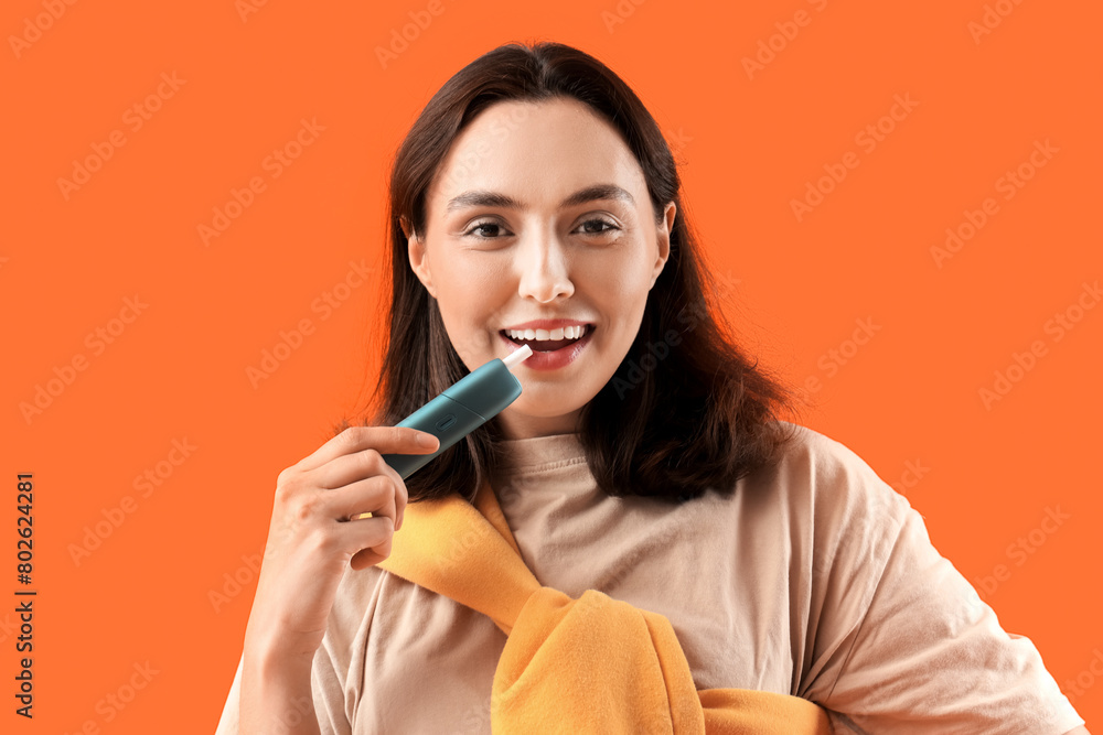 Young woman smoking electronic cigar on orange background, closeup Young woman smoking electronic cigar on orange background, closeup