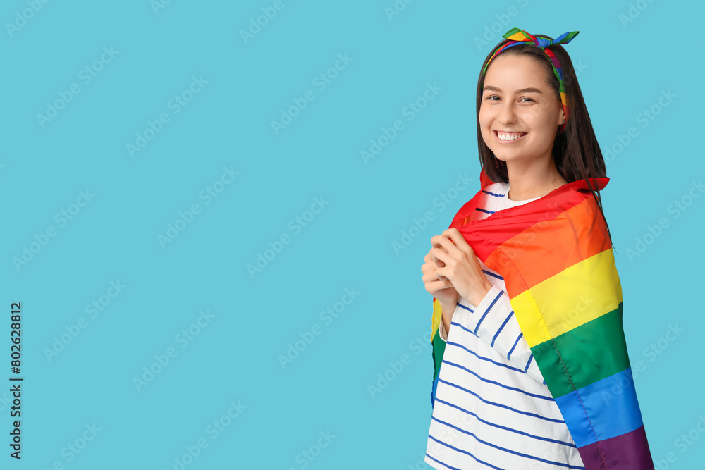 Beautiful young woman in hairscarf with LGBT flag on blue background Beautiful young woman in hairscarf with LGBT flag on blue background