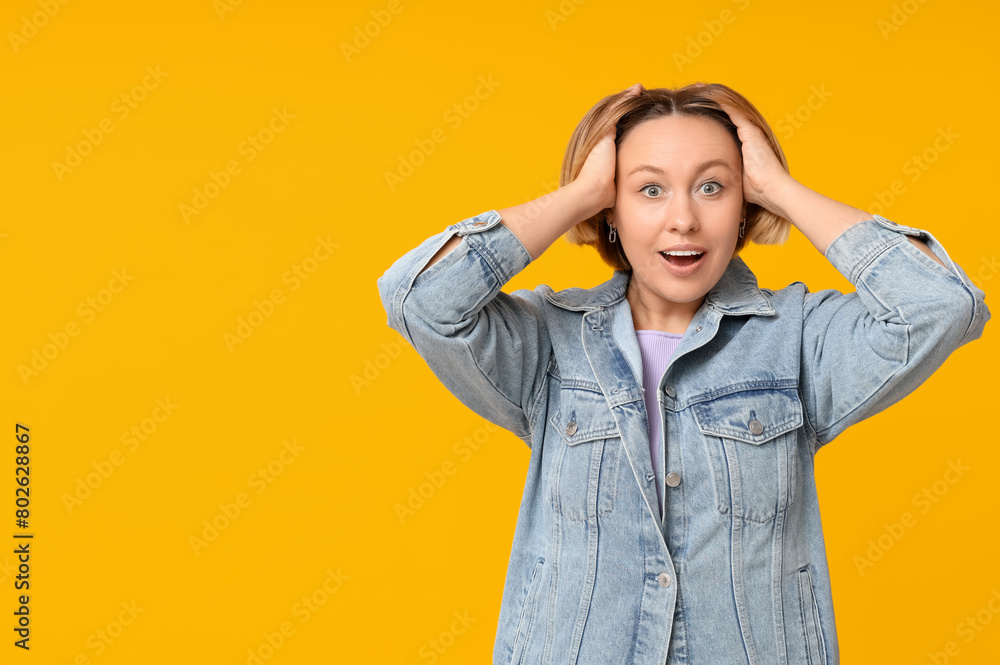 Surprised adult woman on yellow background Surprised adult woman on yellow background
