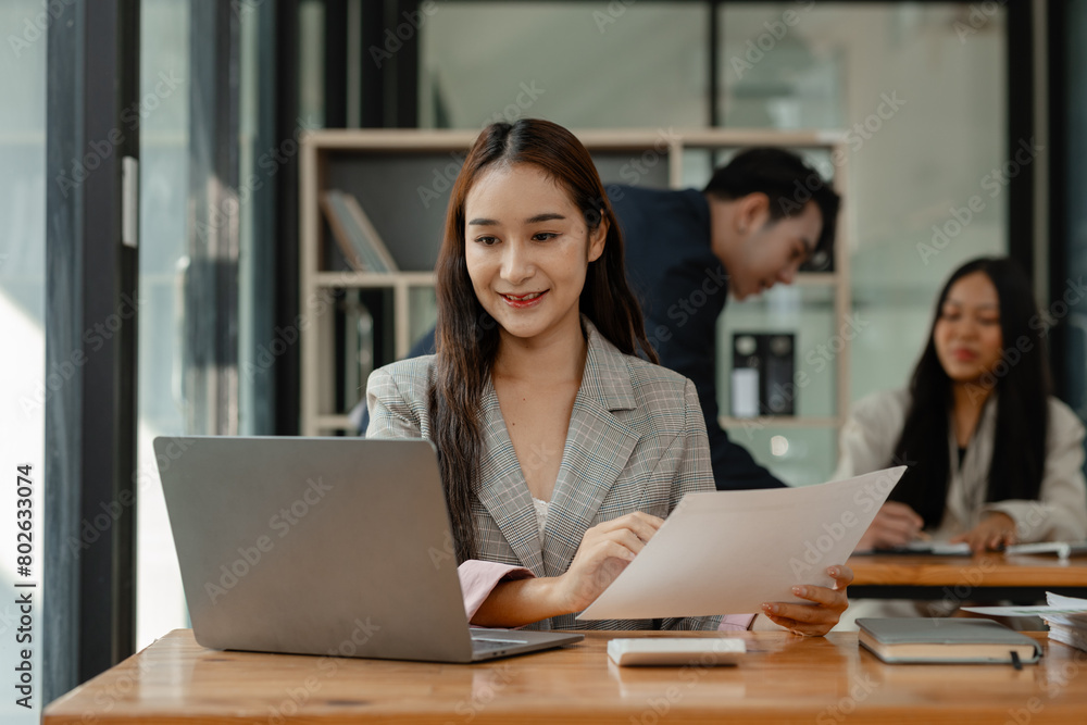 Obraz premium an employee is working in modern office and another coworkers are in the same room, working atmosphere in the office, businesspeople, work happily in the company