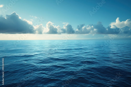 Expansive Ocean Horizon Under a Clear Blue Sky with Cumulus Clouds.
