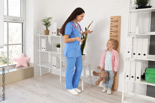 Female pediatrician measuri...