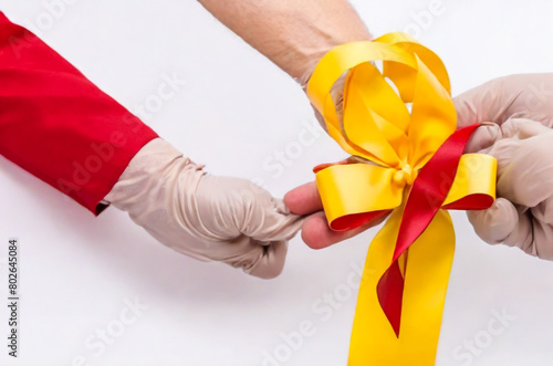 hand holding a red ribbon
