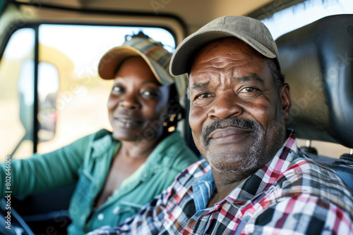 Elderly African American couple enjoying a leisurely drive in their vehicle, sharing stories and smiles on a sunny day. © KirKam