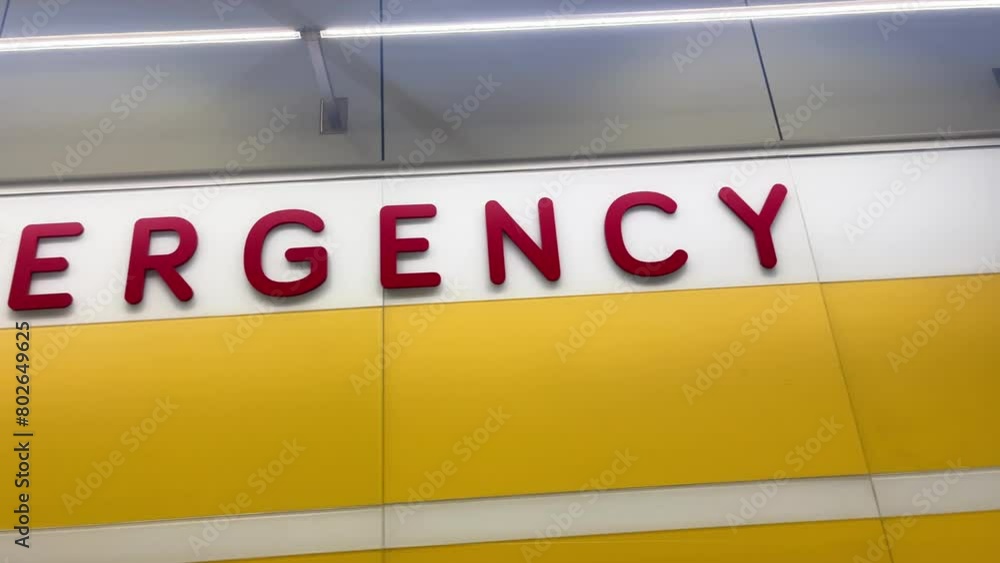 An emergency room sign is inside a hospital ER in red letters for a healthcare rescue concept or medical coverage idea. An emergency room sign is inside a hospital ER in red letters for a healthcare rescue concept or medical coverage idea.