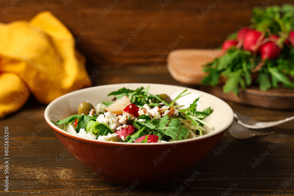 Bowl of tasty salad with radish on wooden table Bowl of tasty salad with radish on wooden table