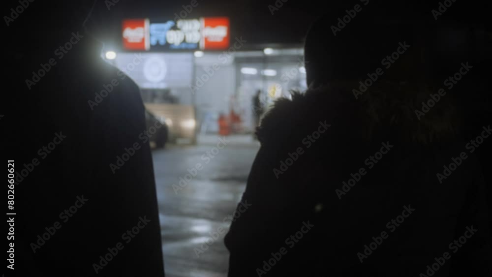 Two men walking up to a grocery store at night Two men walking up to a grocery store at night