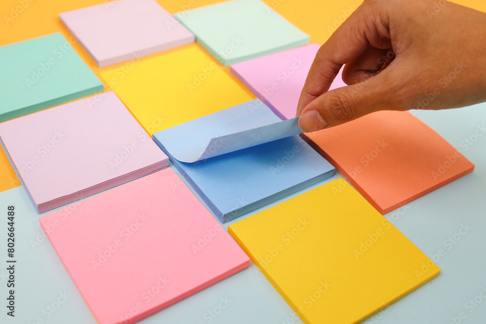 Hand Opening One of Sticky Notes Pages Beetween Colorful Memo Pads Hand Opening One of Sticky Notes Pages Beetween Colorful Memo Pads