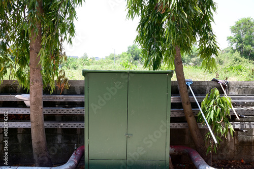 Closeup of Green Steel Cabinet located beside the old wall background at Thailand.