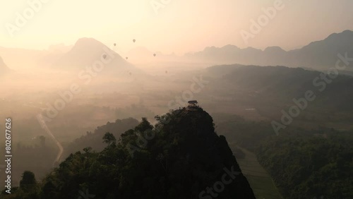 sunrise drone shot of cliffs and hot air balloons in Vang Vieng, the adventure capital of Laos photo