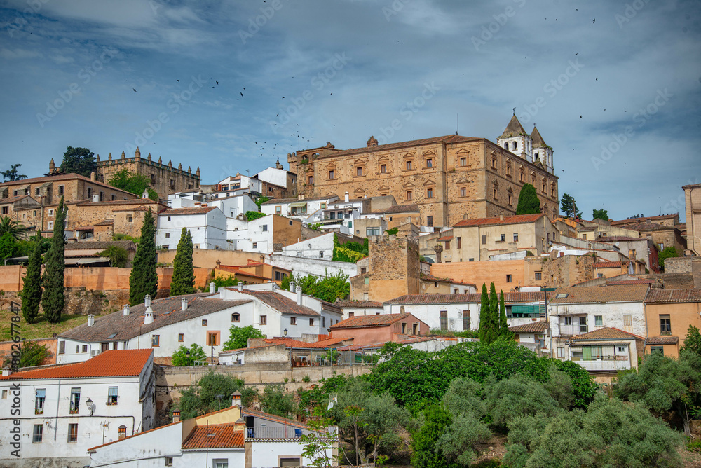 Vista panorámica  del casco histórico de la ciudad española de Cáceres con vistas a los tejados de tejas marrones de edificios antiguos alrededor de la plaza principal en el soleado día de primavera, 