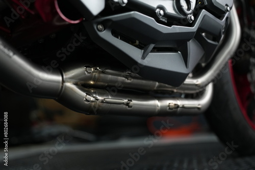 Close-up of motorcycle, car wheel, and exhaust in a vehicle interior 