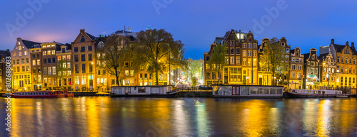 Amsterdam Netherlands, night panorama city skyline at canal waterfront