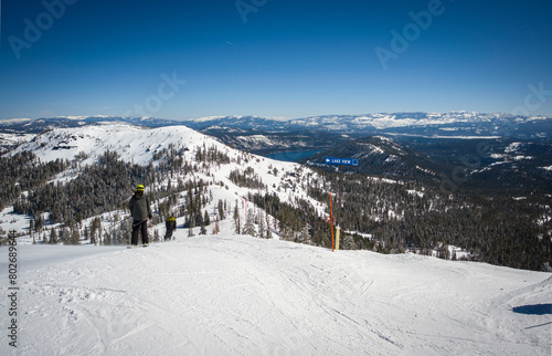Unidentifiable skiiers head down Mt. Lincoln to the Lake View intermediate run at Sugar Bowl Ski Resort. Donner Lake is in the background.