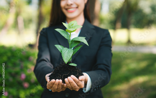 Asian businesswoman holding plant as concept of eco company committed to corporate social responsible, reducing CO2 emission, protect environment, and embrace ESG principle for sustainable future.Gyre photo