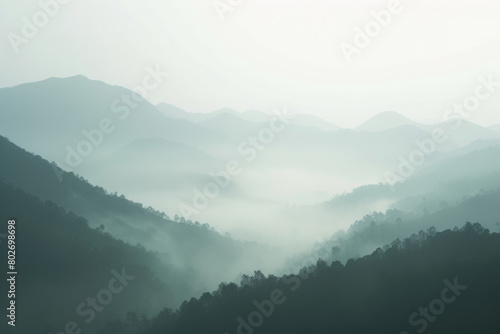 Layers of misty mountains fading into the distance, creating a mystical and serene atmosphere in the early morning light.