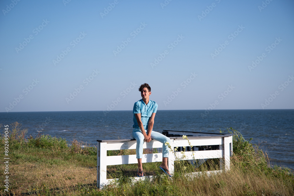Fototapeta premium A young attractive guy is walking on the beach.