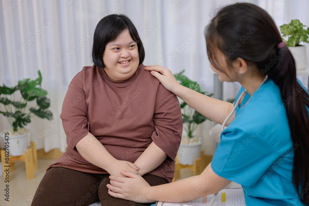 Asian female nurse or therapist Providing counseling to disabled Asian women with Down syndrome. Asian female therapist talks and encourages obese Down syndrome child with depression at home Asian female nurse or therapist Providing counseling to disabled Asian women with Down syndrome. Asian female therapist talks and encourages obese Down syndrome child with depression at home