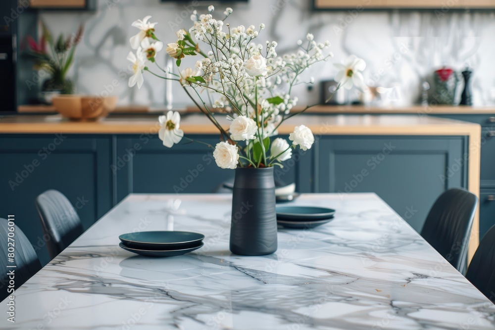 Empty and clean marble dining table in scandinavian kitchen. Modern monochrome interior with blue drawers on wooden furniture. Tablewear and vases with flowers - generative ai