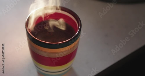 A colourful mug with morning coffee and a lingering aroma. photo