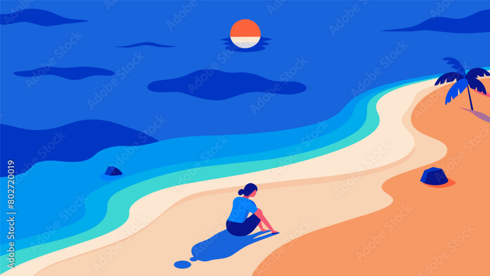 A view of the beach from above a person sitting alone in the sand surrounded by the calming blue hues of the ocean and the setting sun..
