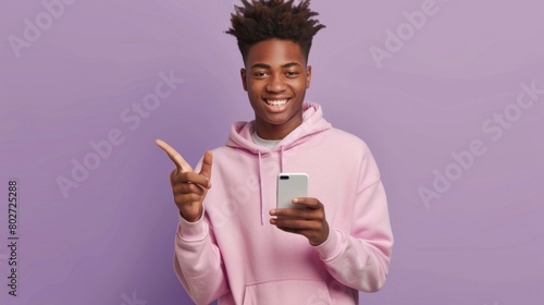 Young African American male in pink hoodie using smartphone, pointing with a smile, AI Generative.