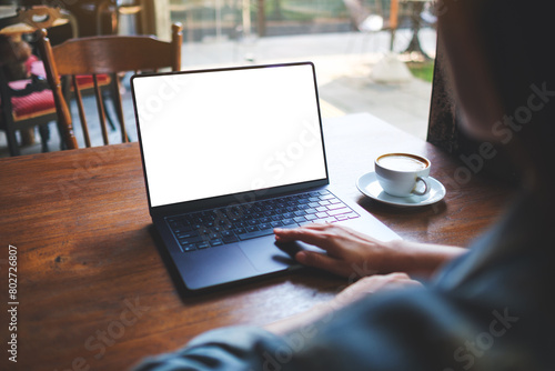 Mockup image of a woman working and touching on laptop computer with blank white desktop screen