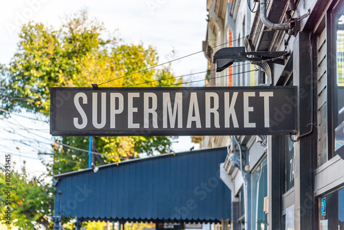 A sign with the word 'Supermarket' is attached to a shopfront