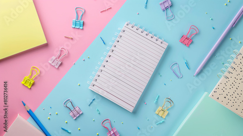 Notebook with binder clips on color background