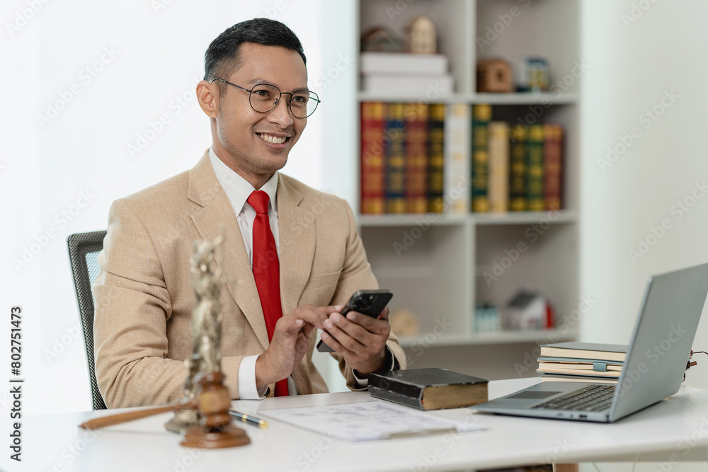 Obraz premium Male lawyer working in the office with contracts and legal documents when sitting at the advice table. Justice and Real Estate Man or judge discusses team meeting with clients online