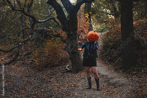 Photography Person wearing carved Halloween pumpkin head holding a lantern