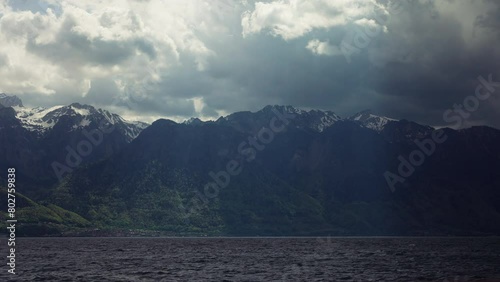 Geneva lake in Switzerland, with French Alps on the background and cloudy sky