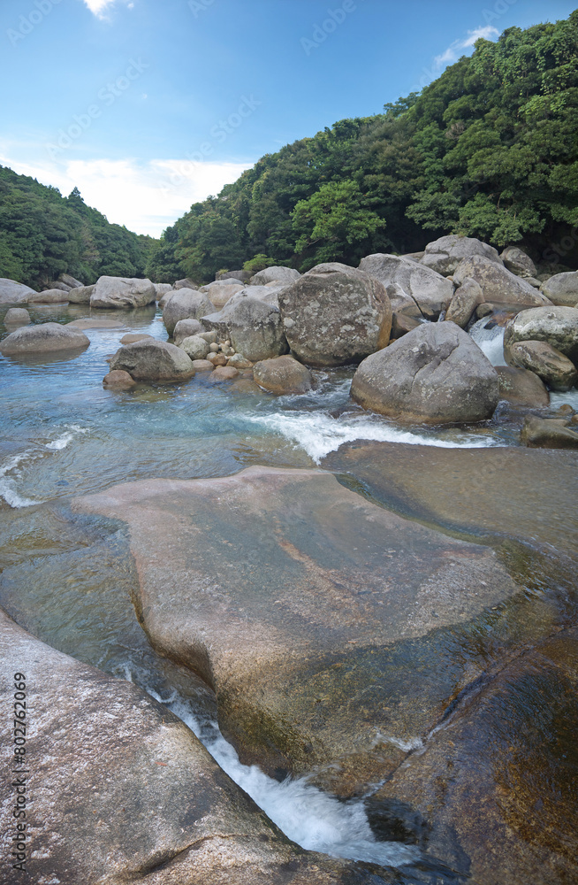 Yakushima nature scenery with Mountain river stone riverbank and small natural pond with big boulders and green forest