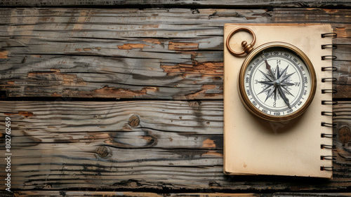 A compass is on top of a notebook